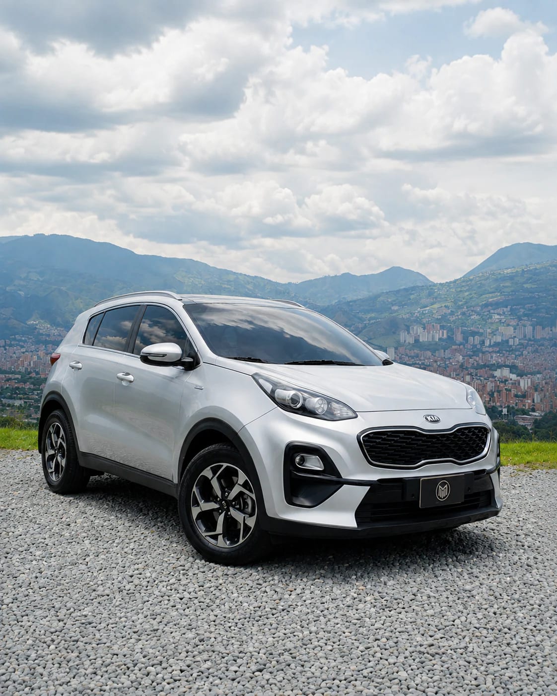 Frente de la Kia Sportage plateada: parrilla en nido de abeja, faros y antiniebla.
