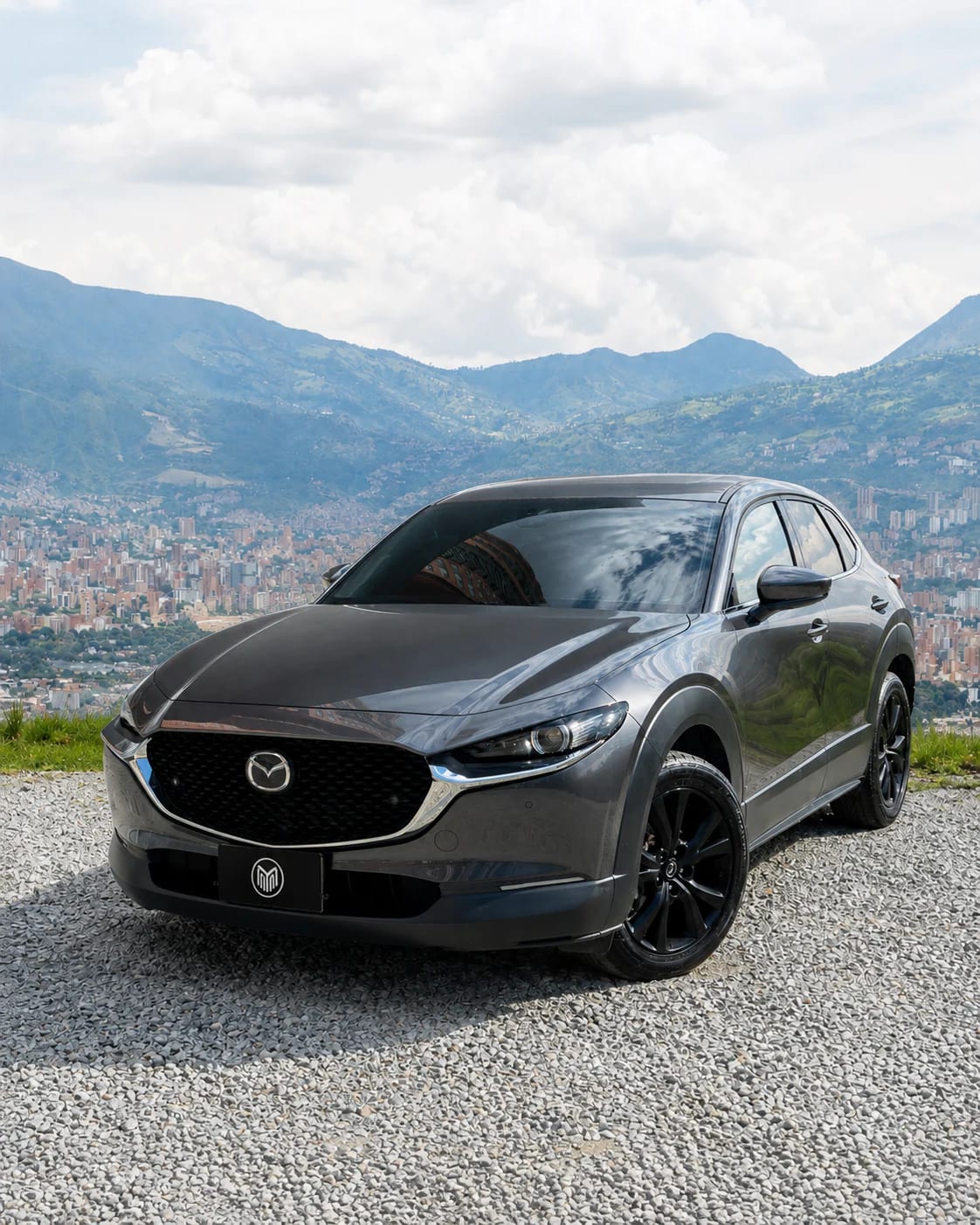 Front of the graphite grey Mazda CX-30: grille, sharp headlights and sculpted bonnet.