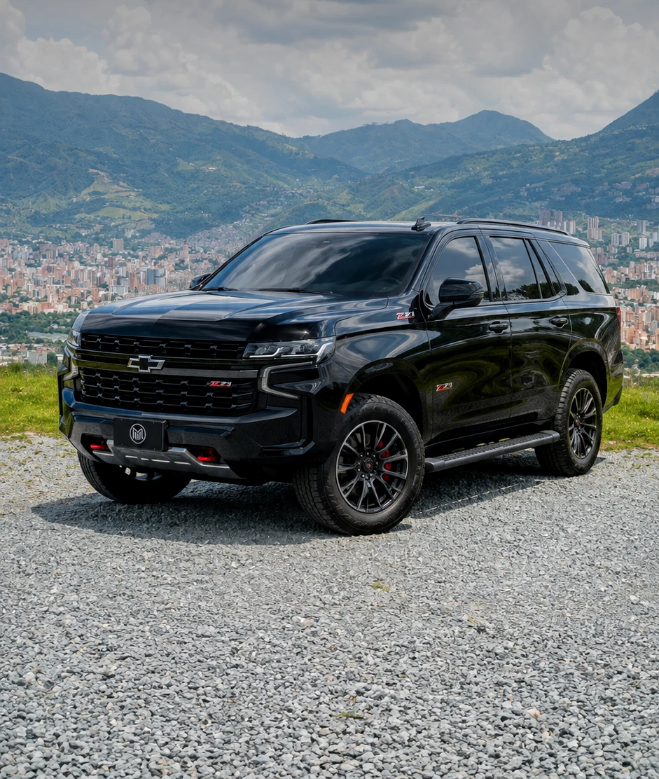Black Chevrolet Tahoe Z71 at a lookout over the Medellín valley, with the city and the mountains behind.